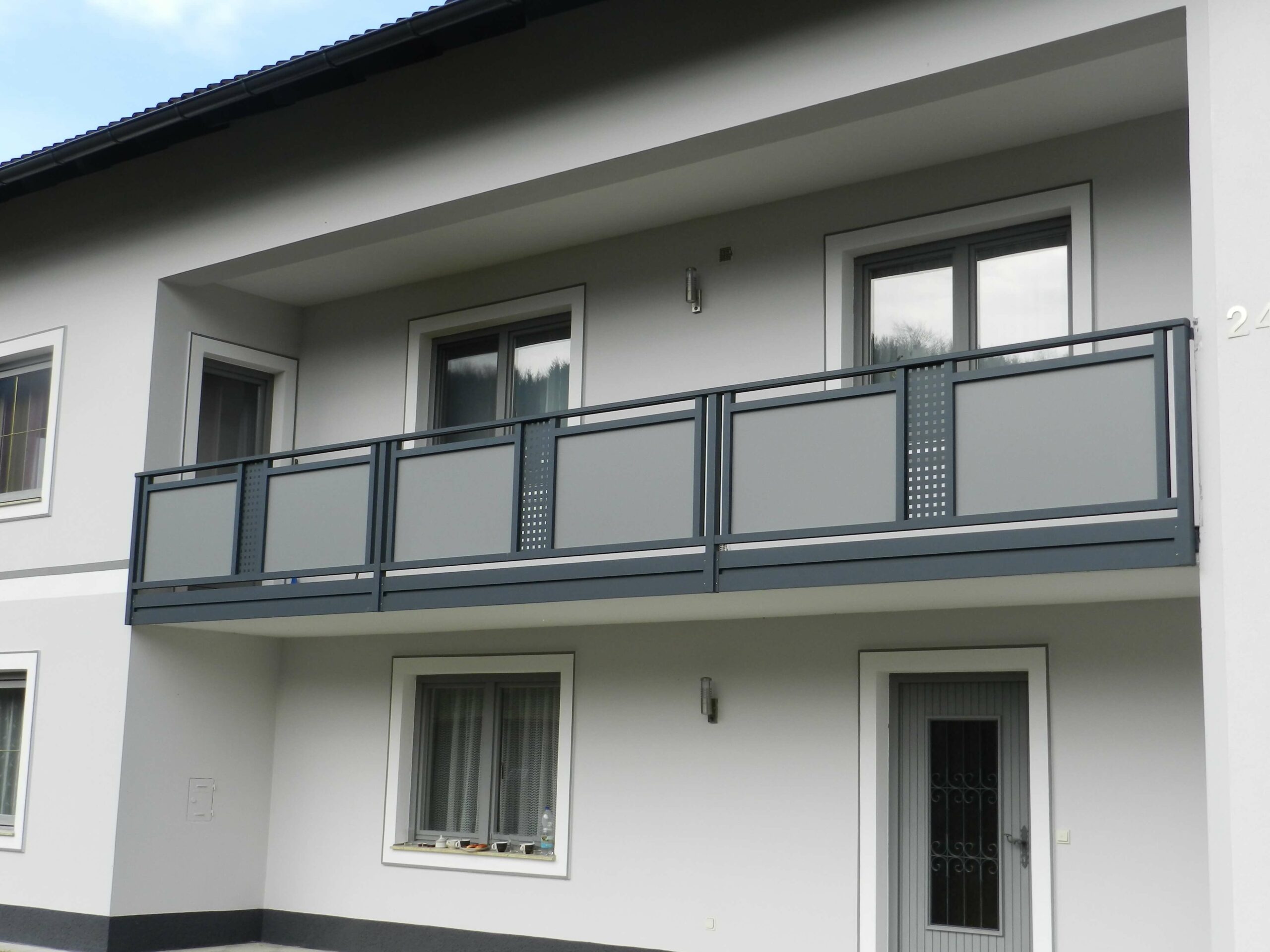Dunkelgrauer Alubalkon an einem hellgrauen Haus