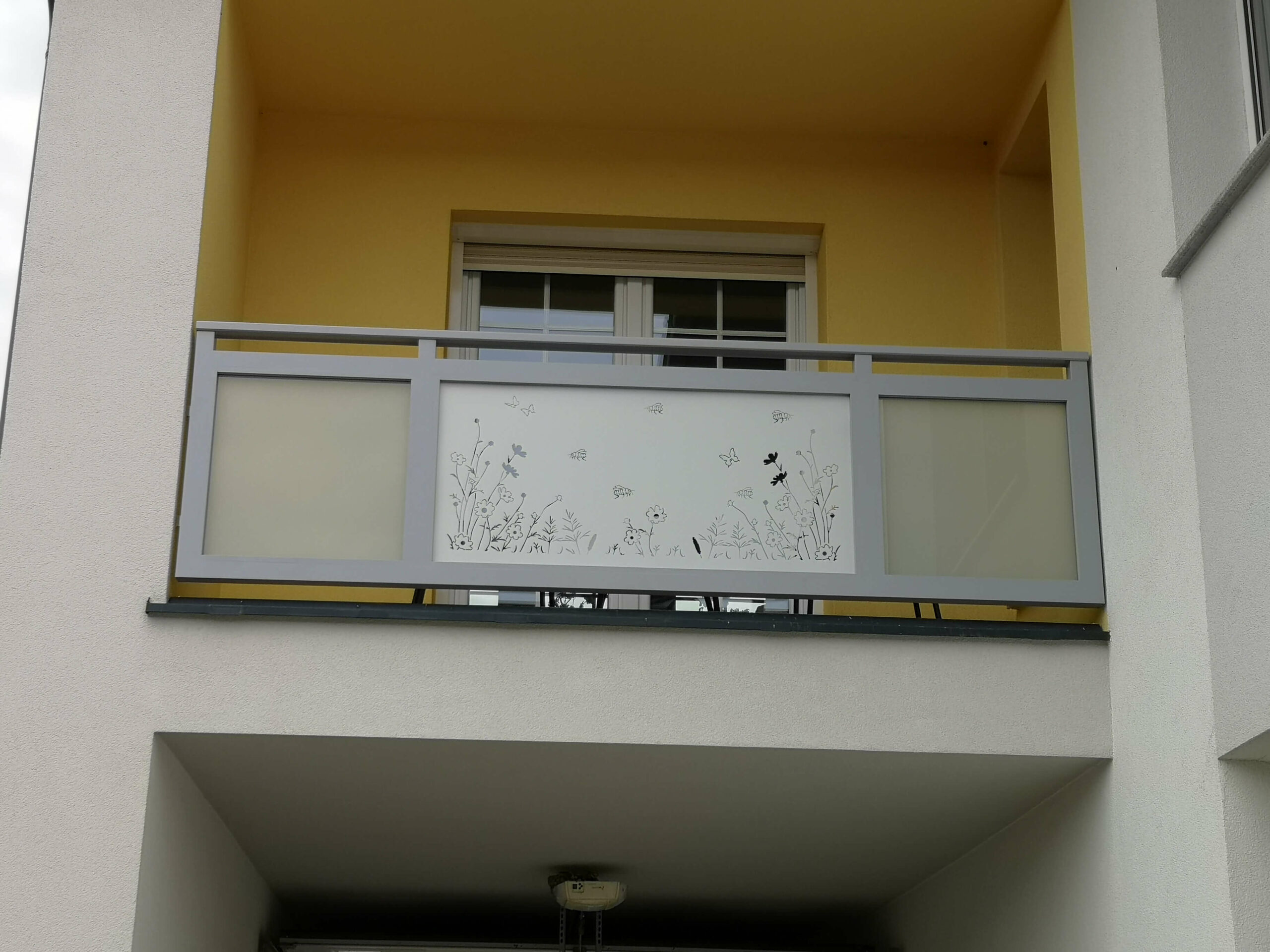Hellgrauer Alubalkon mit Glaselementen und Wiesenmuster