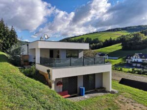 Grauer Alubalkon an einem weißen Haus