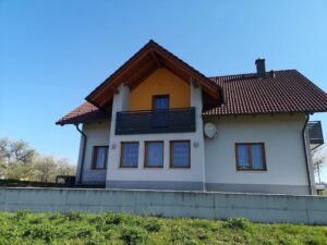 Dunkelgrauer Alubalkon an einem hellgrauen Haus