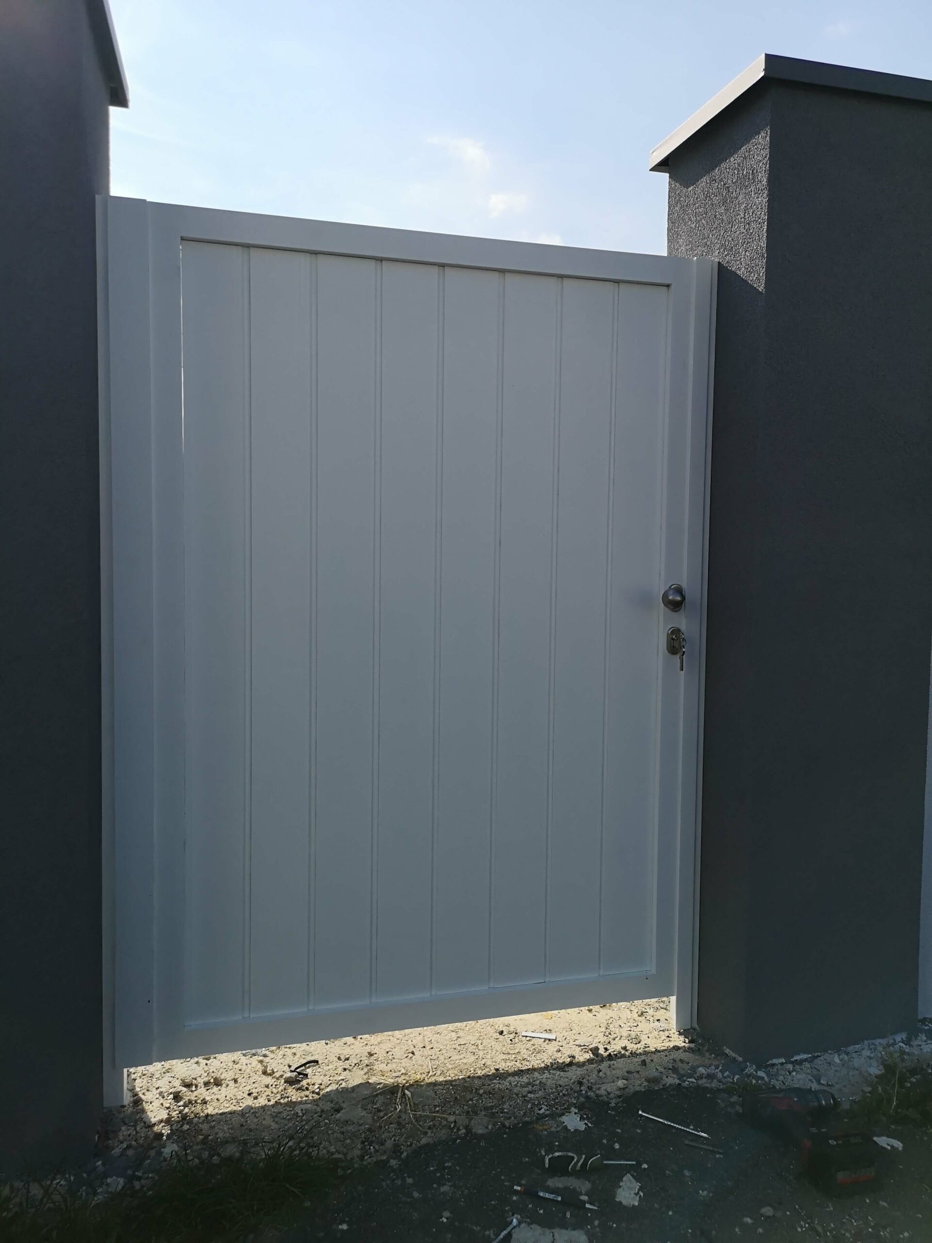 Weißes Tor in einer grauen Mauer