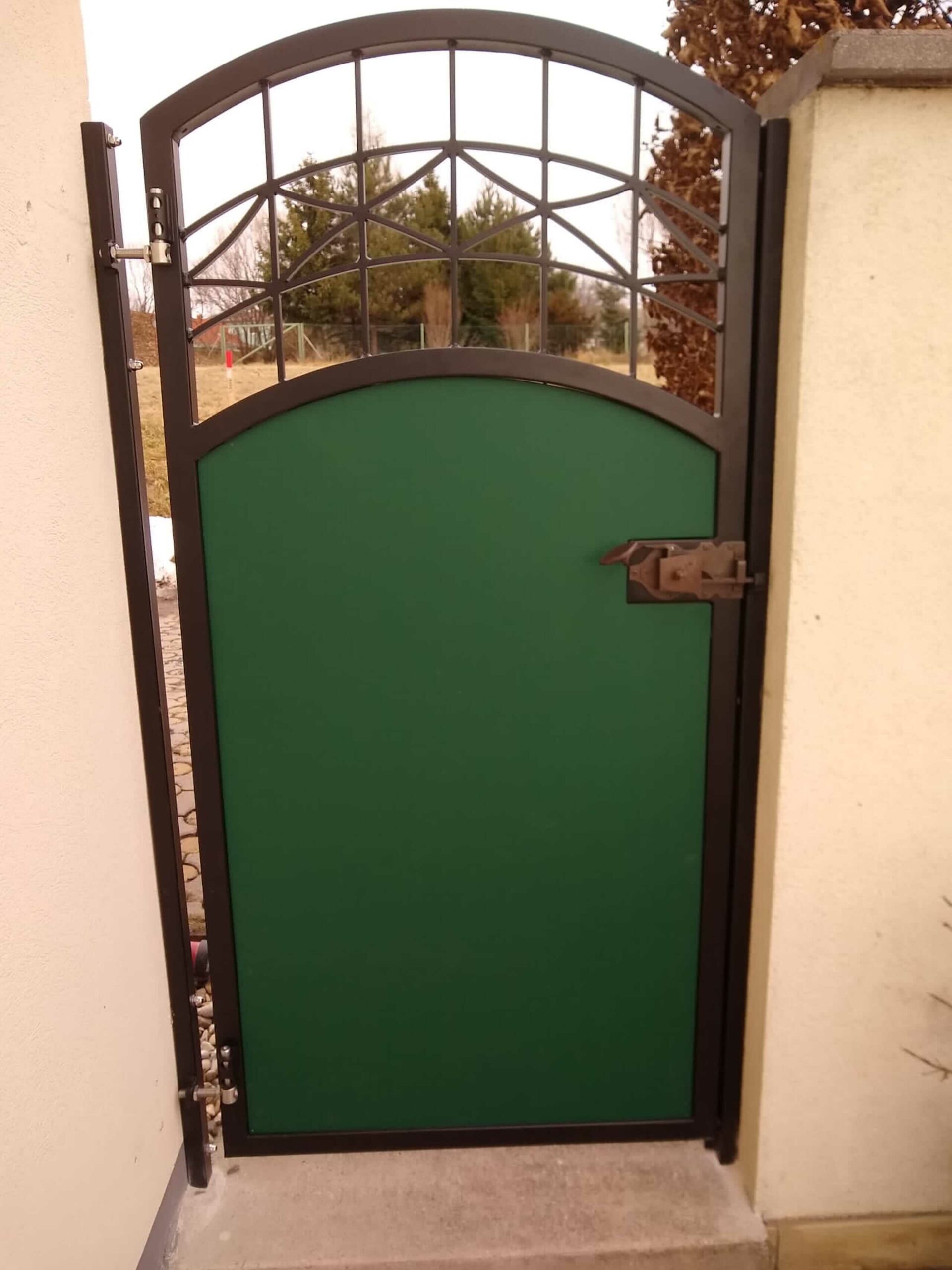 Grünes Eisentor mit grauer Fassung