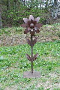 Braune Blume aus Metall auf einer Wiese