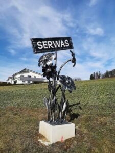 Blumenstrauß aus Metall mit einem Schild Serwas